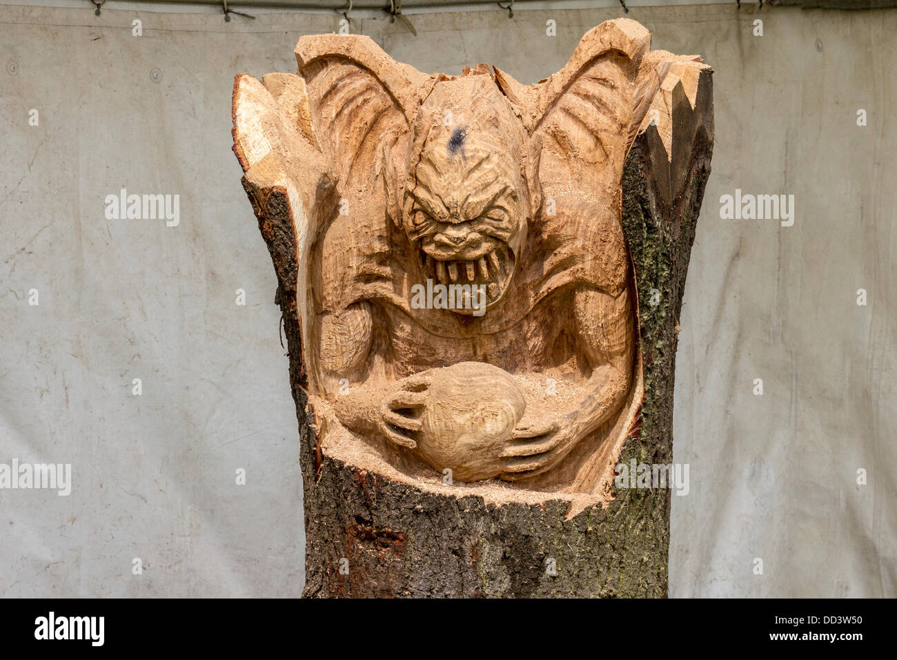 Andy Burgess carving Yoda at the 9th English Open Chainsaw Carving Competition,  Cheshire County Showground, Game and County Fair. The chainsaw carvers  use wood (sometimes huge bits) to produce beautiful carvings of up to 20 feet high. when each one becomes a sought after work of art. Wood sculpture, sawdust, sculptor, timber, chips, log, professional, working, art, artist, cut, chain saw, artwork made from rough timber log. Stock Photo