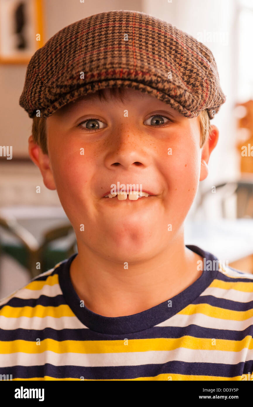 A 9 year old boy wearing a cap and pulling a funny face in the Uk Stock Photo