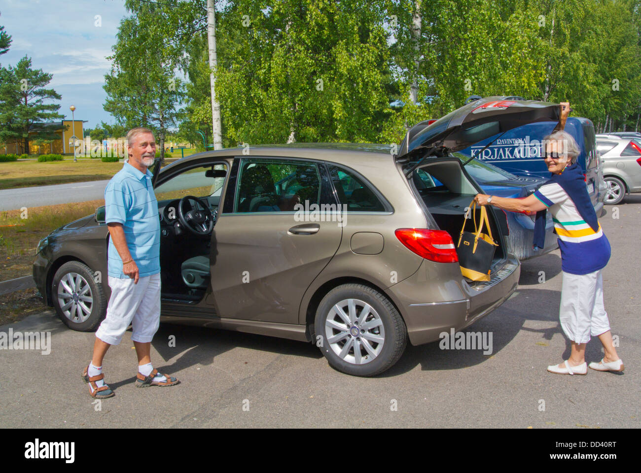Couple in their 70s getting into the new car Pori Finland northern Europe Stock Photo