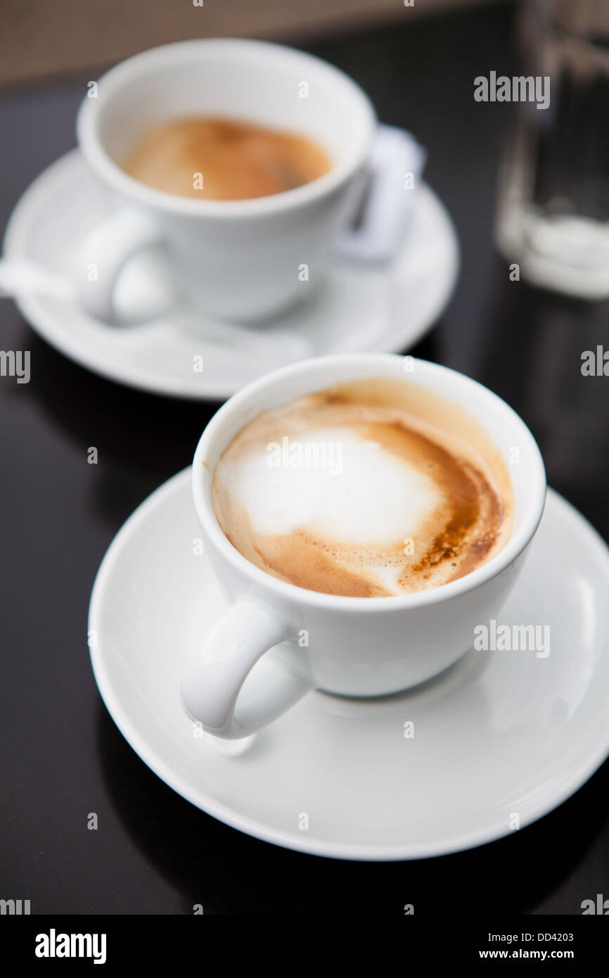 Closeup of two milk based coffees in white cups on cafe table Stock Photo