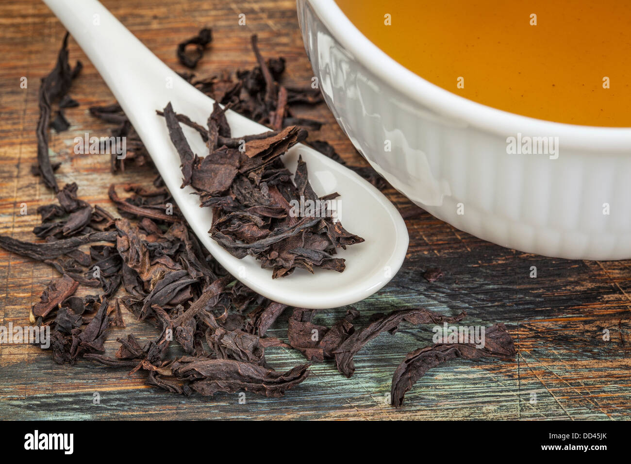 a cup of oolong black tea with loose leaf and teaspoon Stock Photo