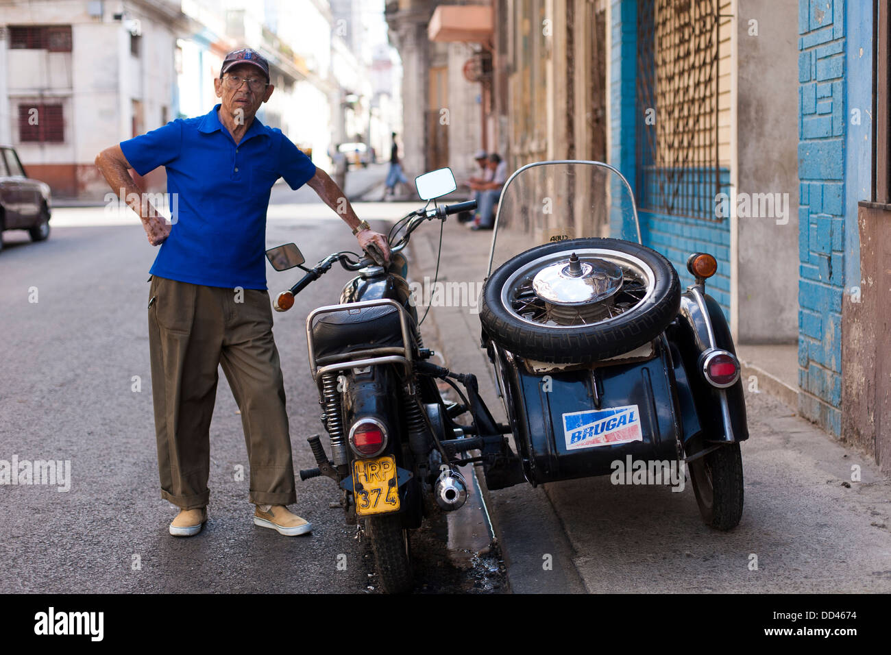 A man poses with his east German motorbike and sidecar in Havana, capitol city of Cuba Stock
