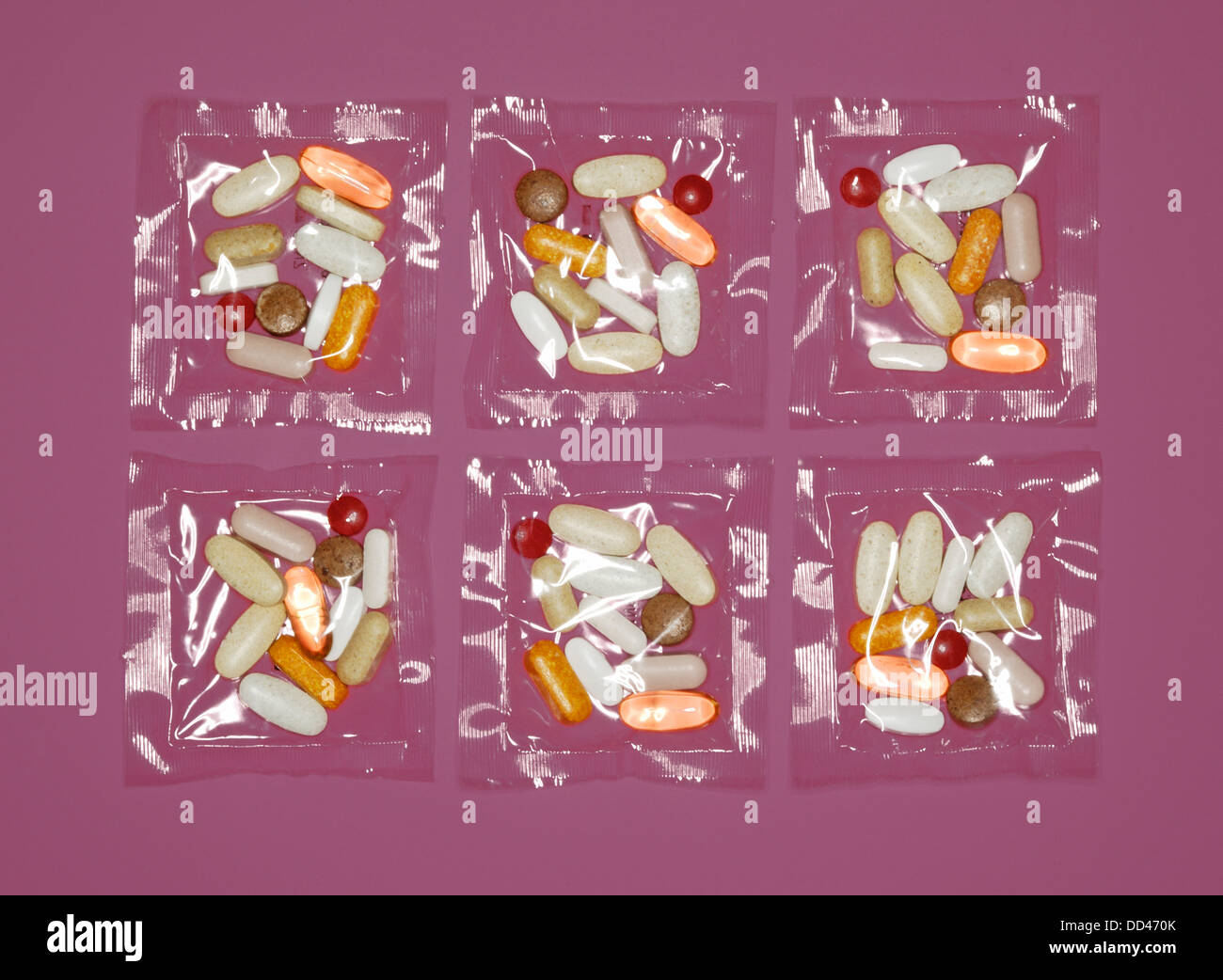 A plastic clear packets of vitamin supplements - pills, capsules and tablets. Red and purple background Stock Photo