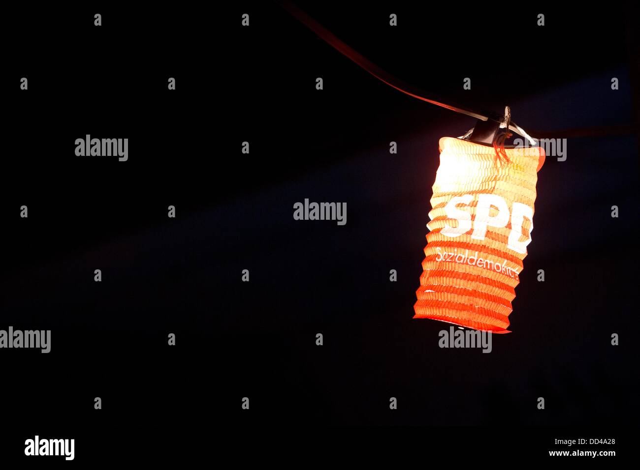 A single red lantern with the logo of the German Social Democratic Party (SPD) hangs amid other lanterns on a string of lights at a campaign event of the Hamburg SPD candidate Hakverdi at a summer feast on the fruit farm Jonas in Neuenfelde in the south of Hamburg, Germany, 09 August 2013. Germany holds general elections on 22 September 2013. Photo: Christian Charisius Stock Photo