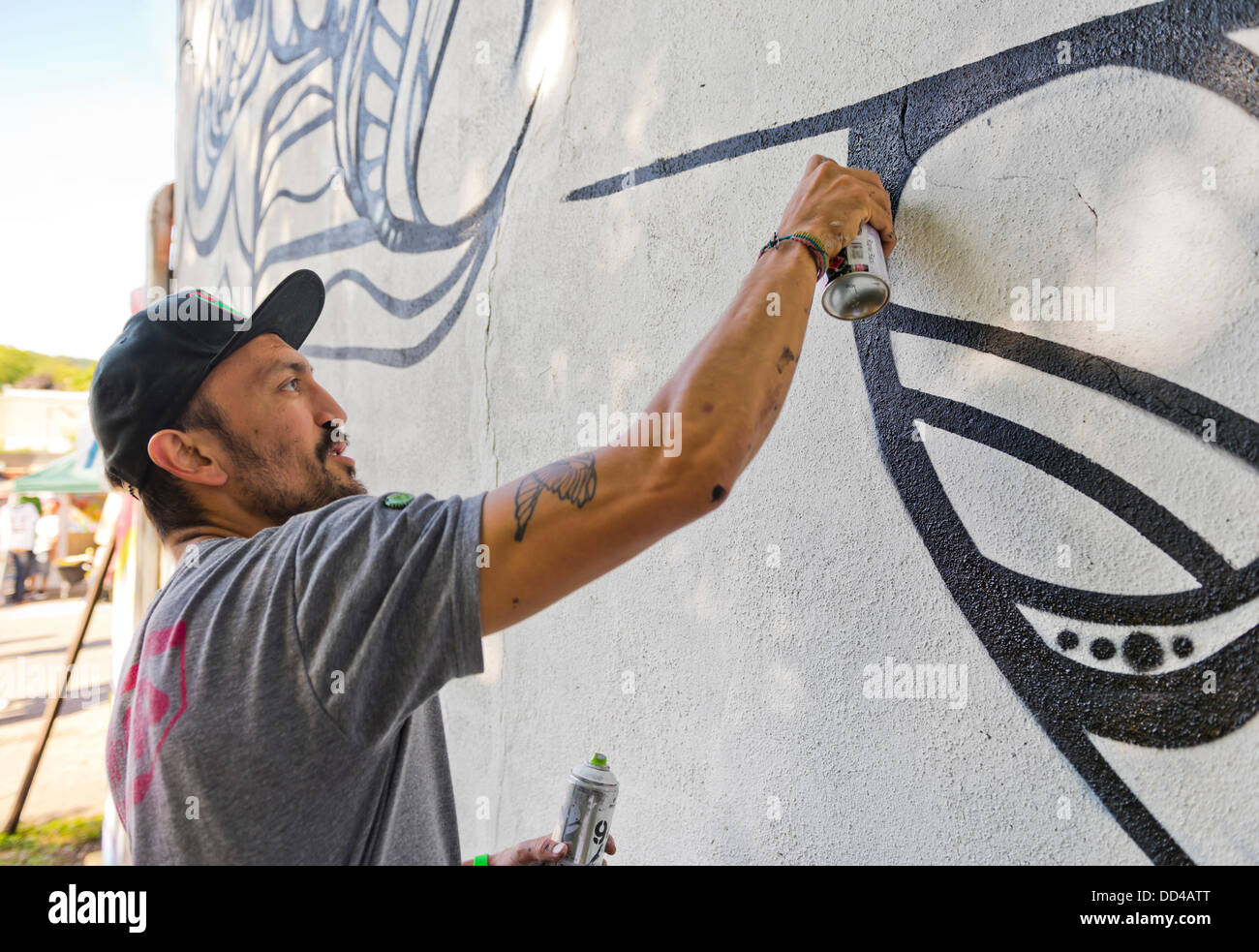 Huntington, New York, U.S. 24th August 2013. MASPAZ, world renowned street artist  FEDERICO FRUM from Washington DC, is painting black and white graffiti on  the back of the Huntington Arts Council building,