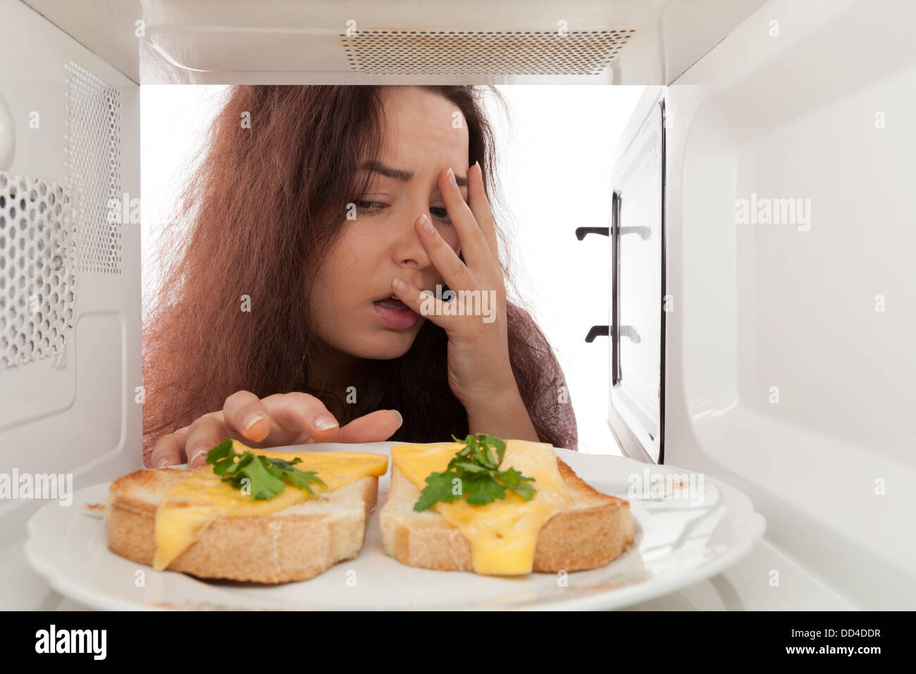 Attractive girl looks in a microwave Stock Photo Alamy