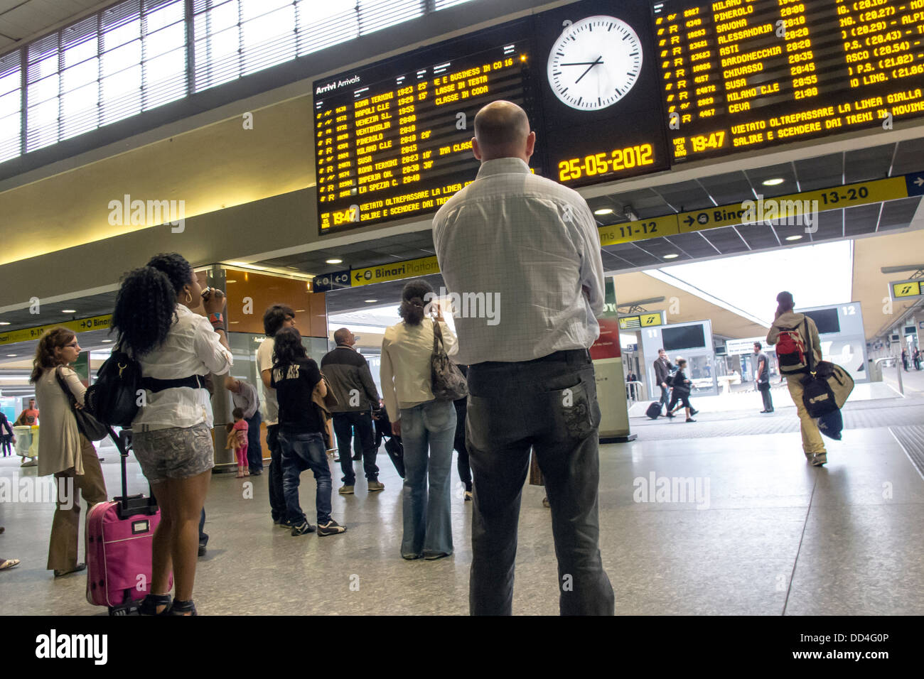 People looking at arrivals and departure board at Florence railway station. Stock Photo