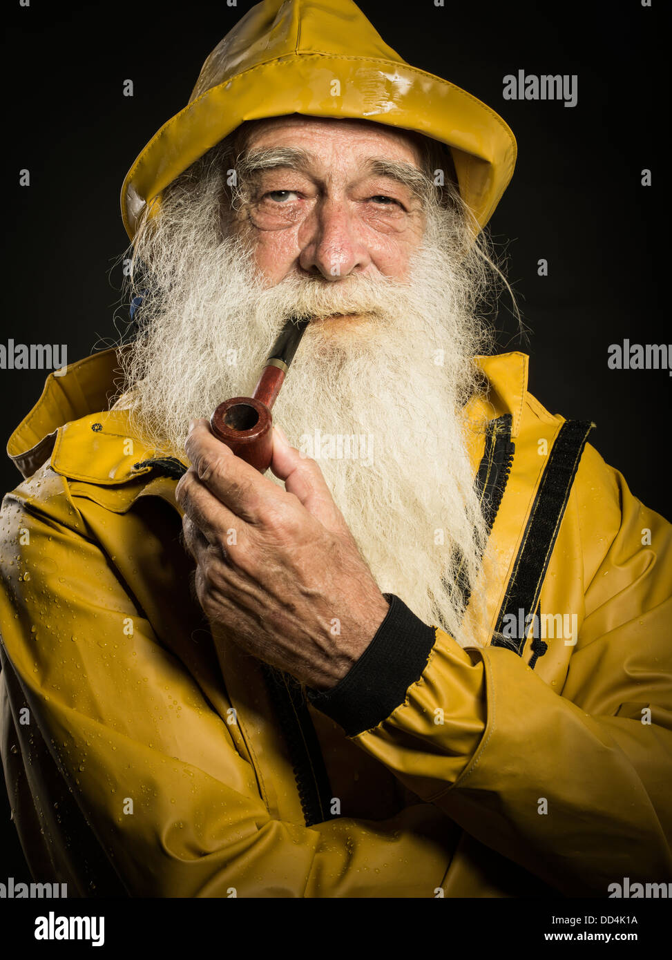 old fisherman with white beard wearing sou'wester hat and guy cotten oilskin jacket Stock Photo