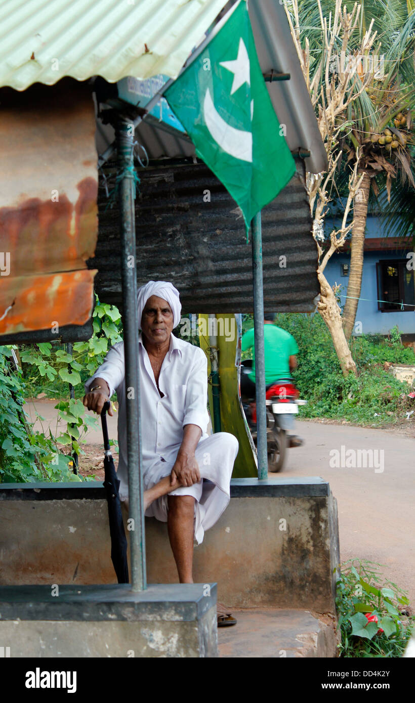 A muslim man sitting next to a muslim league flag, malapuram, Kerala, india Stock Photo