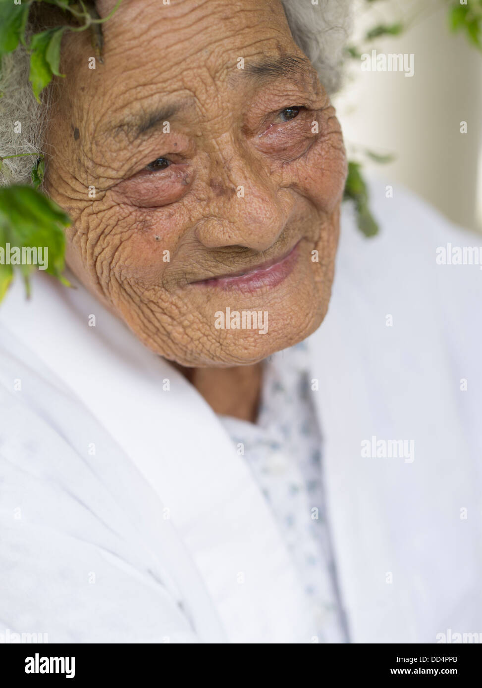 96 year old Kaneshi Fusae wearing wreath of ryukyu botanzuru at Unjami Festival on Kouri Island, Okinawa Stock Photo