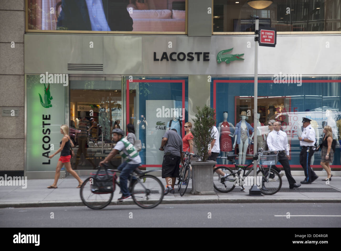 People walk passed LACOSTE store 5th Avenue New York City Stock Photo -