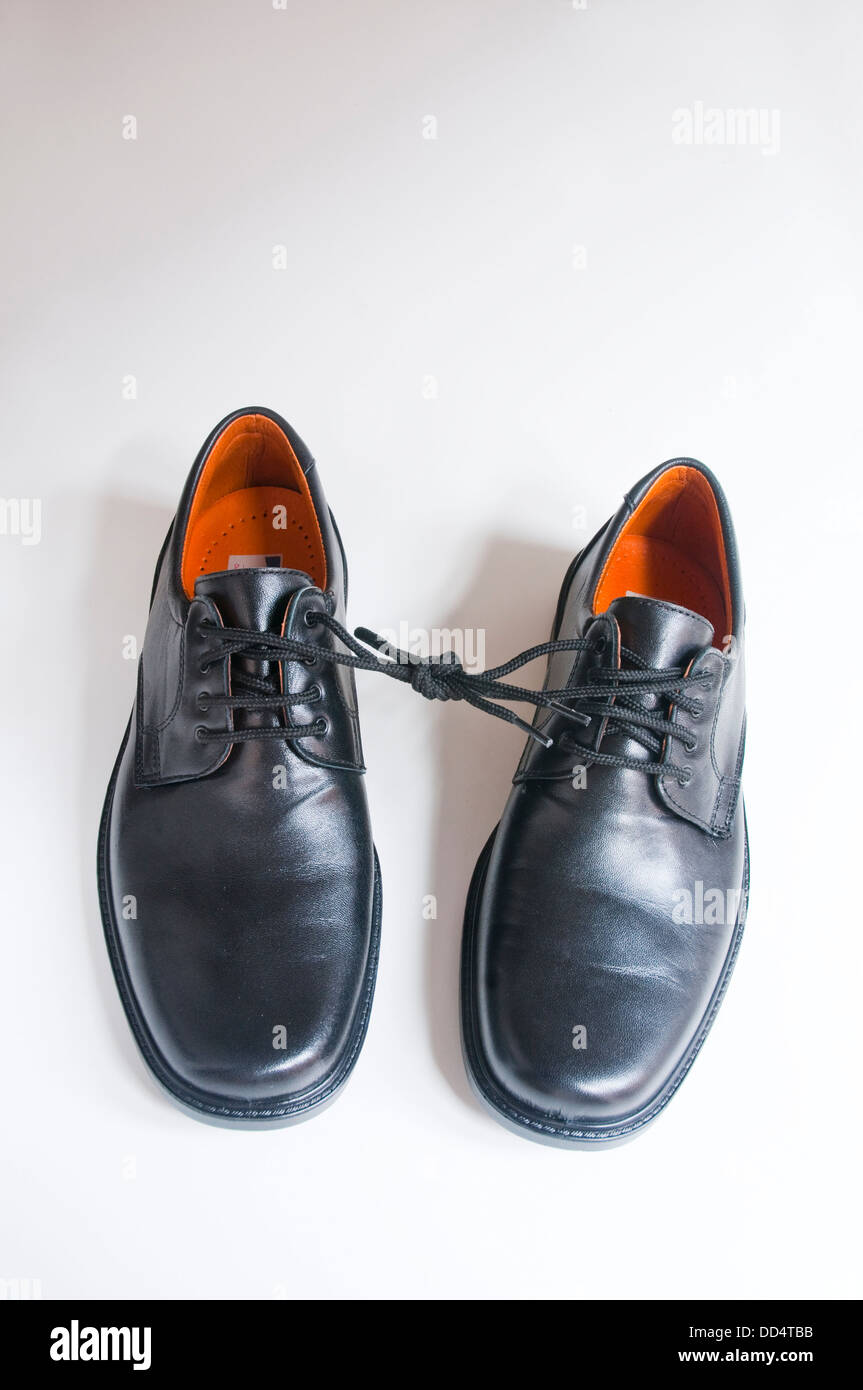 Pair of shoes with their laces tied each other. Stock Photo