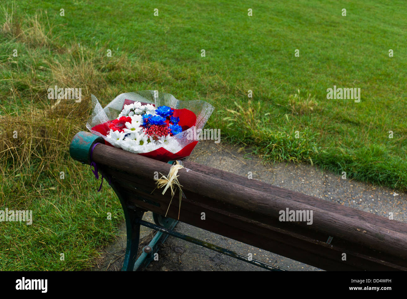 Memorial flowers on park bench Stock Photo Alamy