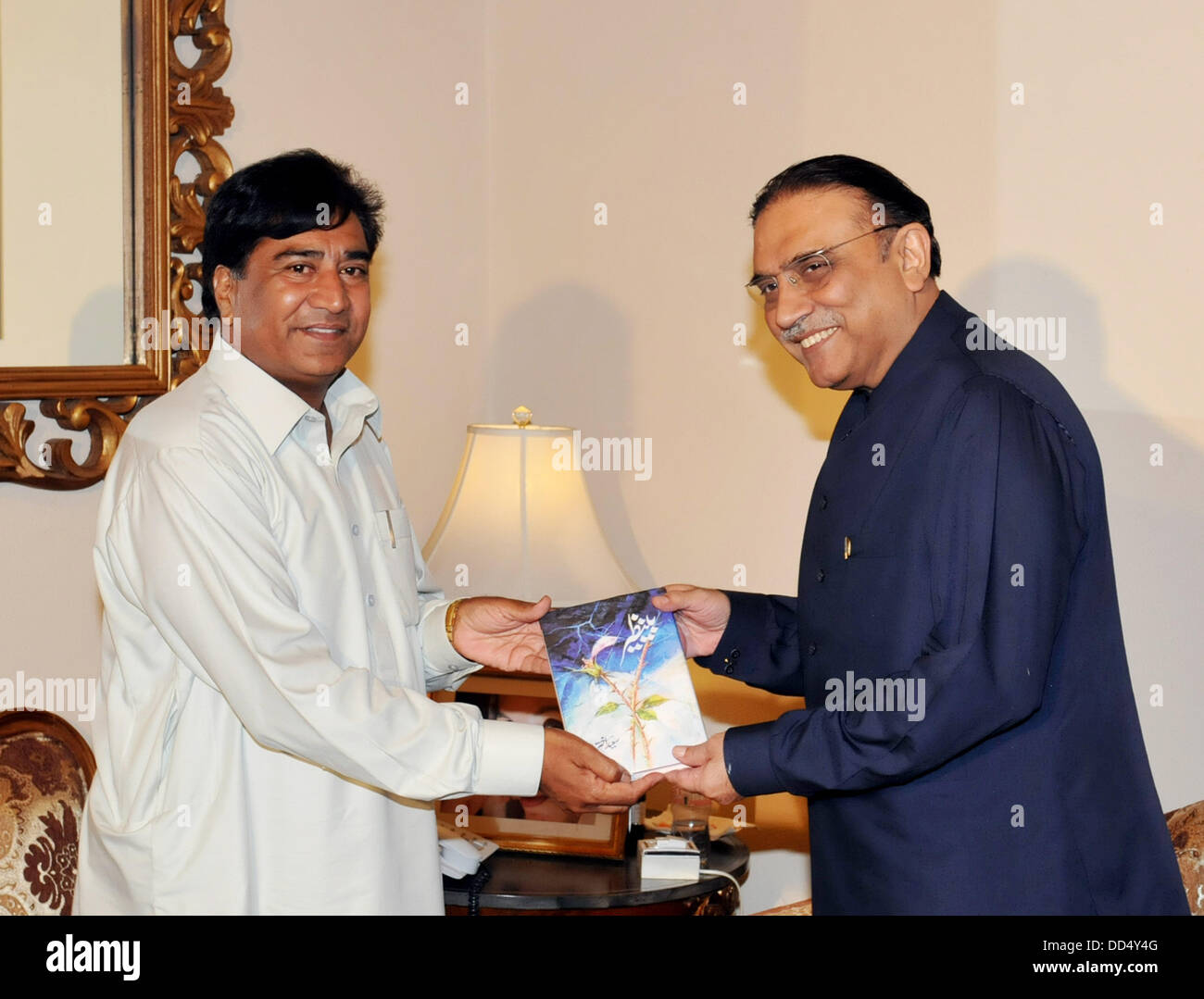 ISLAMABAD/ PAKISTAN .   saeed akhtar presenting his book to president   to asif ali zardari  on 26 august 2013 Handout by Pakistan informtion department      (Photo by PID/Deanpictures) Stock Photo