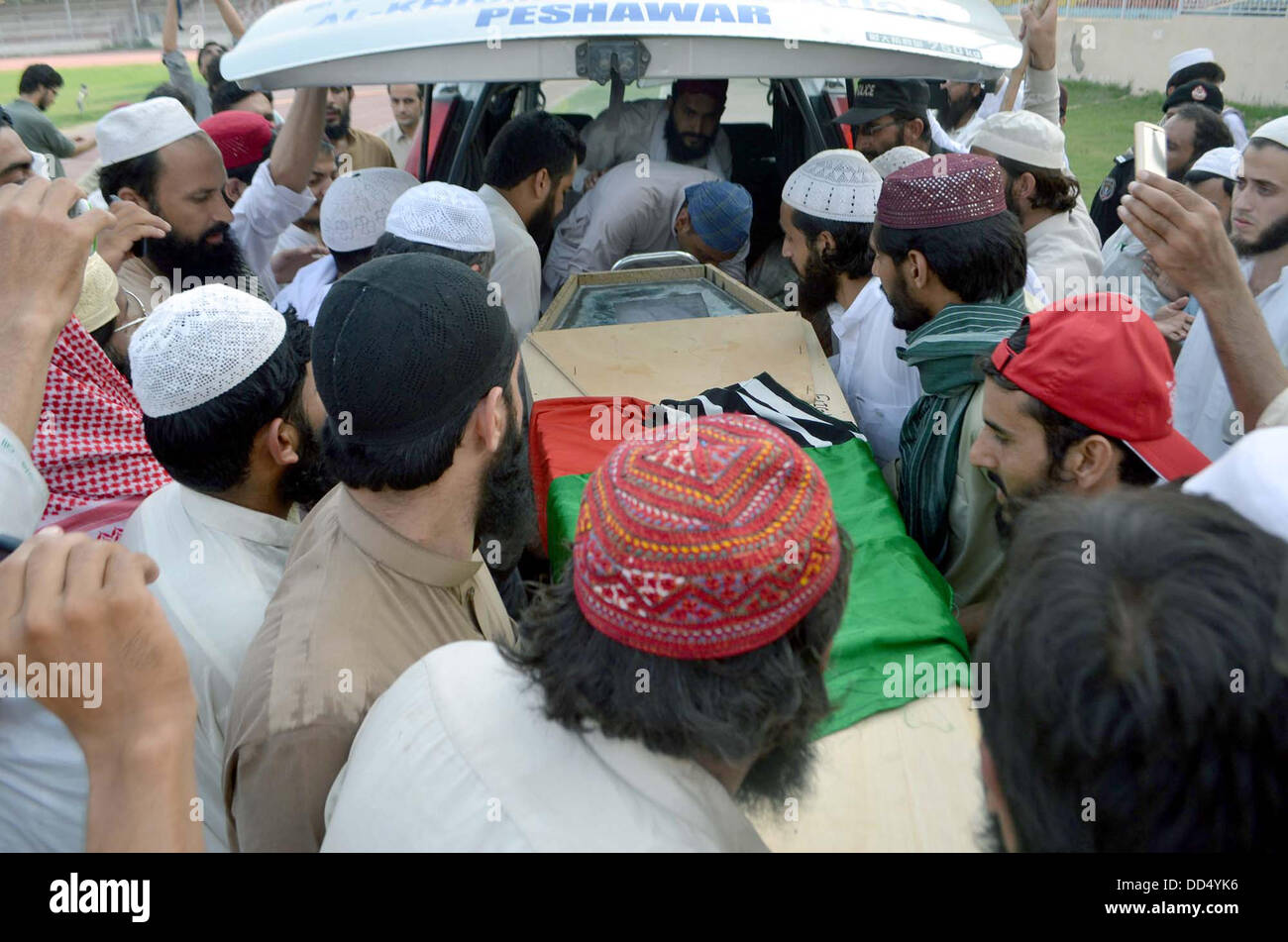 Activists of Ahle Sunnat Wal Jamat carry funeral of their leader and spokesman, Akbar Saeed Farooqi who gunned down by unidentified gunmen in Gulshan-e-Iqbal on Sunday in Karachi, on Qayyum Stadium in Peshawar on Monday, August 26, 2013. Stock Photo