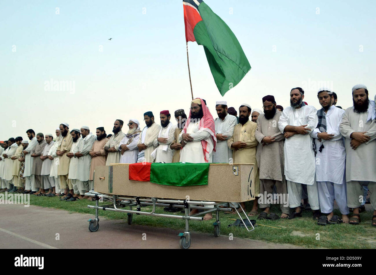 Activists of Ahle Sunnat Wal Jamat offering funeral prayer of their leader and spokesman, Akbar Saeed Farooqi who gunned down by unidentified gunmen in Gulshan-e-Iqbal on Sunday in Karachi, on Qayyum Stadium in Peshawar on Monday, August 26, 2013. Stock Photo