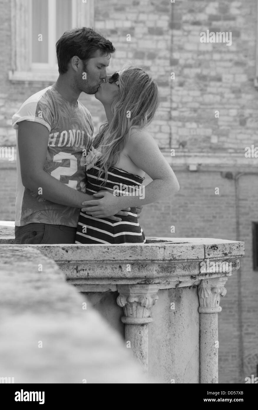 couple kissing on a balcony in Italy Stock Photo