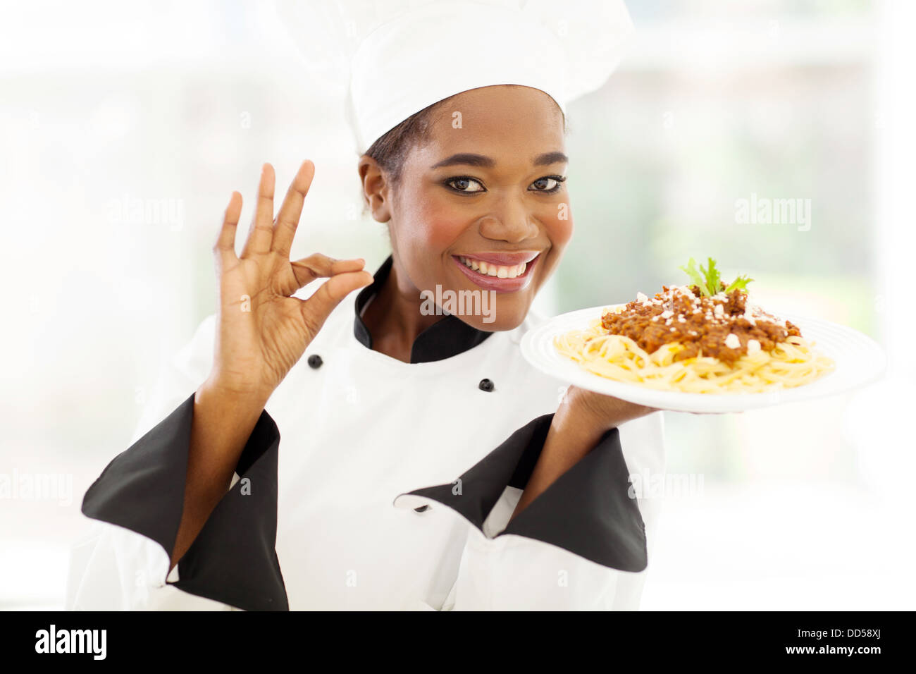 attractive young African chef with delicious pasta dish Stock Photo