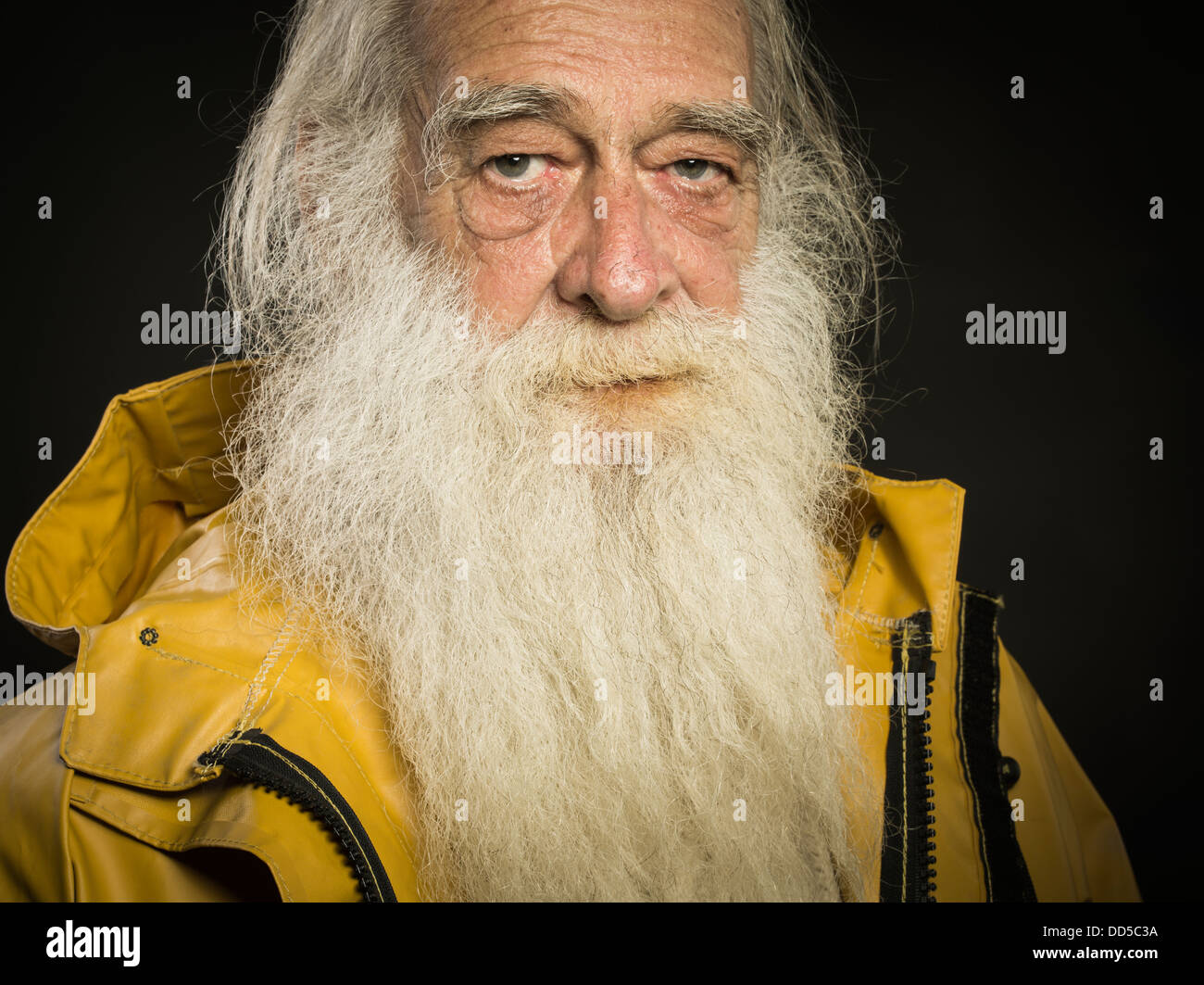 old fisherman with white beard wearing sou'wester hat and guy cotten oilskin jacket Stock Photo