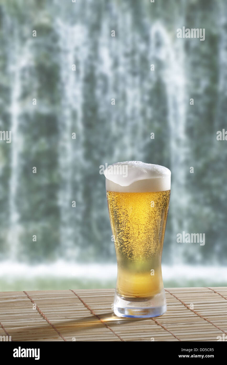 Glass of beer and waterfall Stock Photo