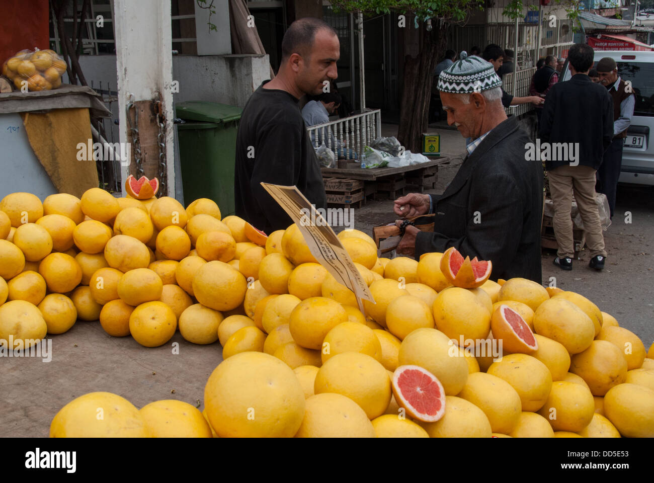 An unidentified old man with traditional cap sells grapefruits in an open market on April 19, 2009 in Izmir, Turkey. Stock Photo