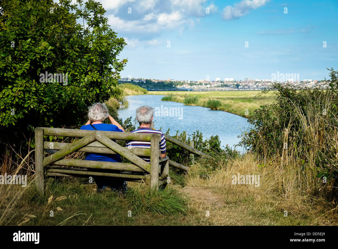 Couple sitting on bench looking at sea view hi-res stock photography ...
