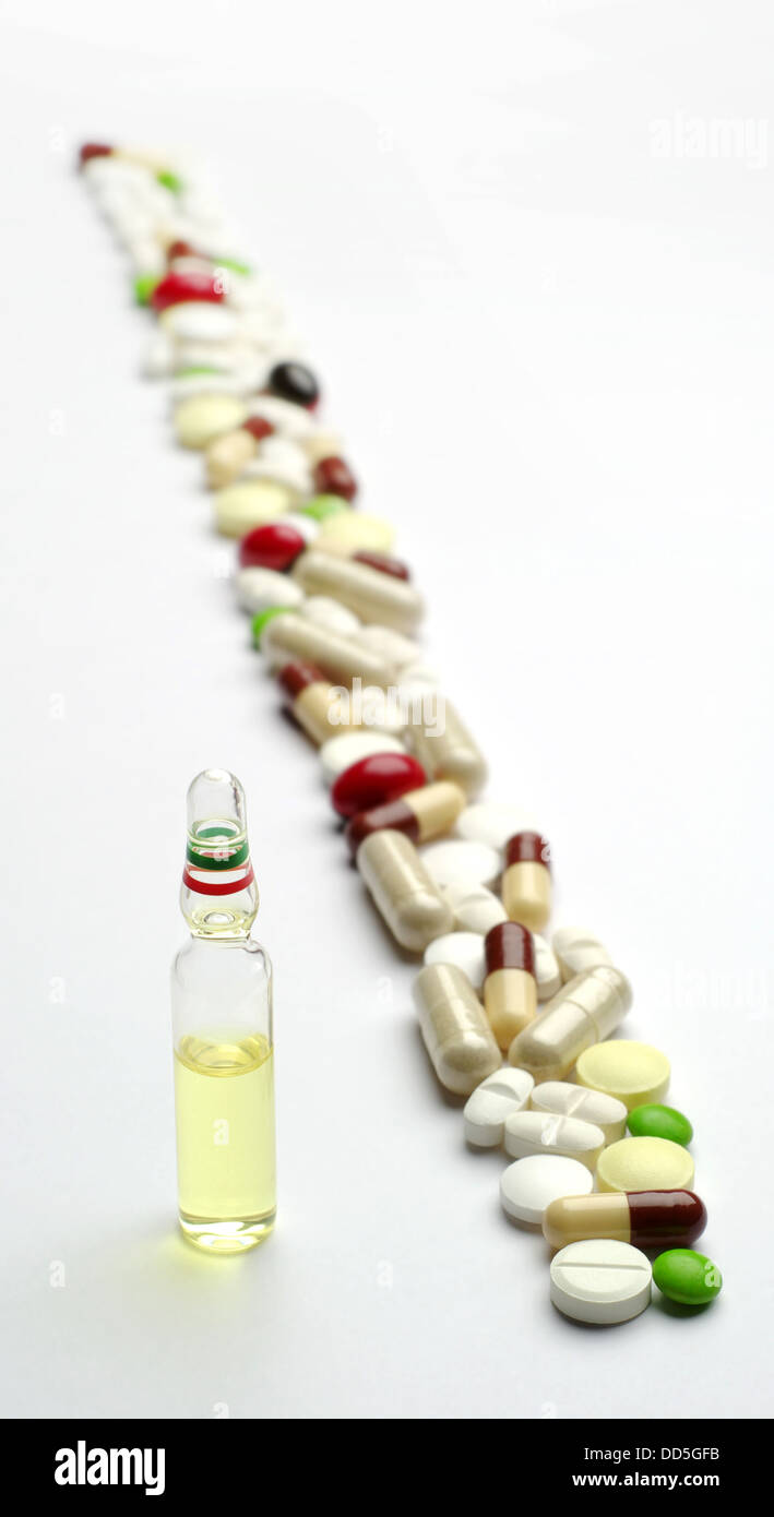 Ampule with medicine and different pills diagonally Stock Photo
