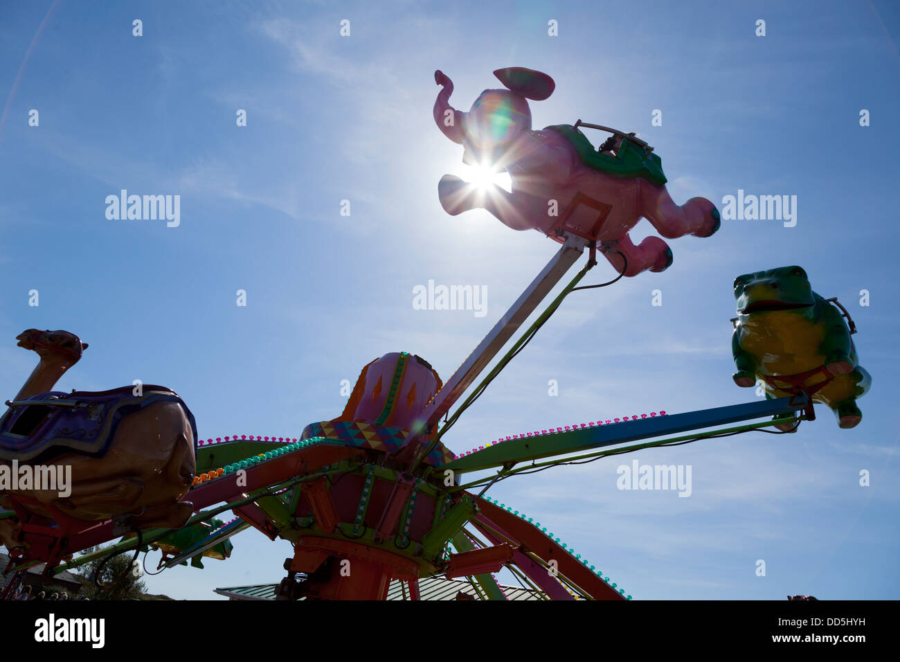 sunburst through flying fantasy animal ride fairground ride Stock Photo