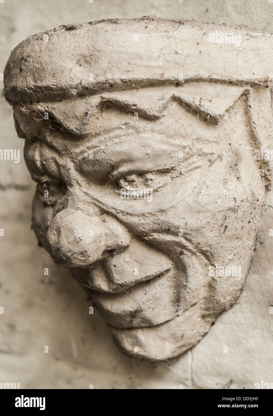 Old stone jester head decoration on outside of building. Stock Photo