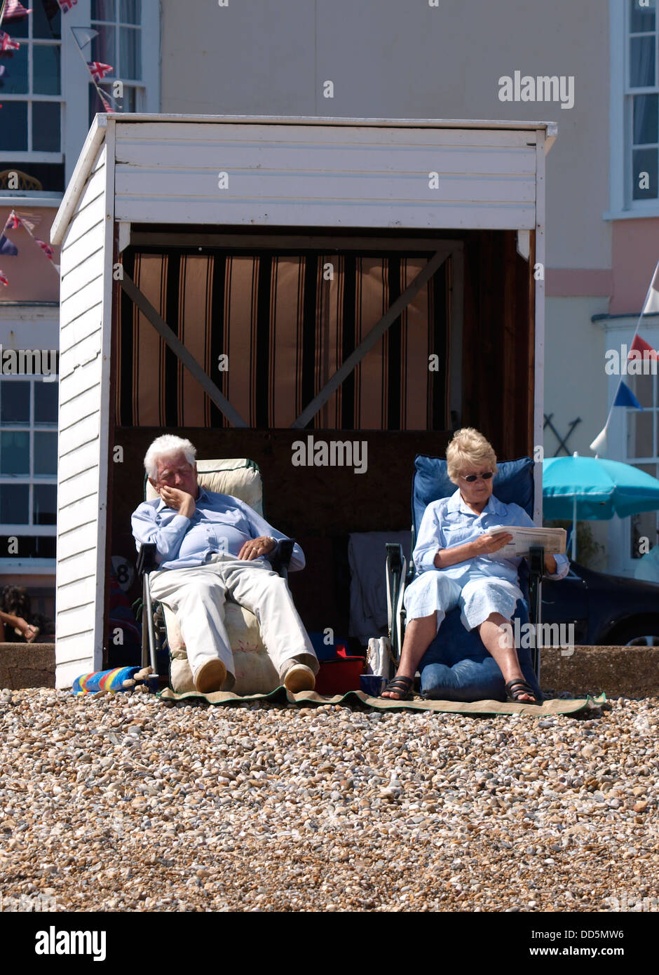 Old couple sat outside beach hut, Weymouth, Dorset, UK 2013 Stock Photo