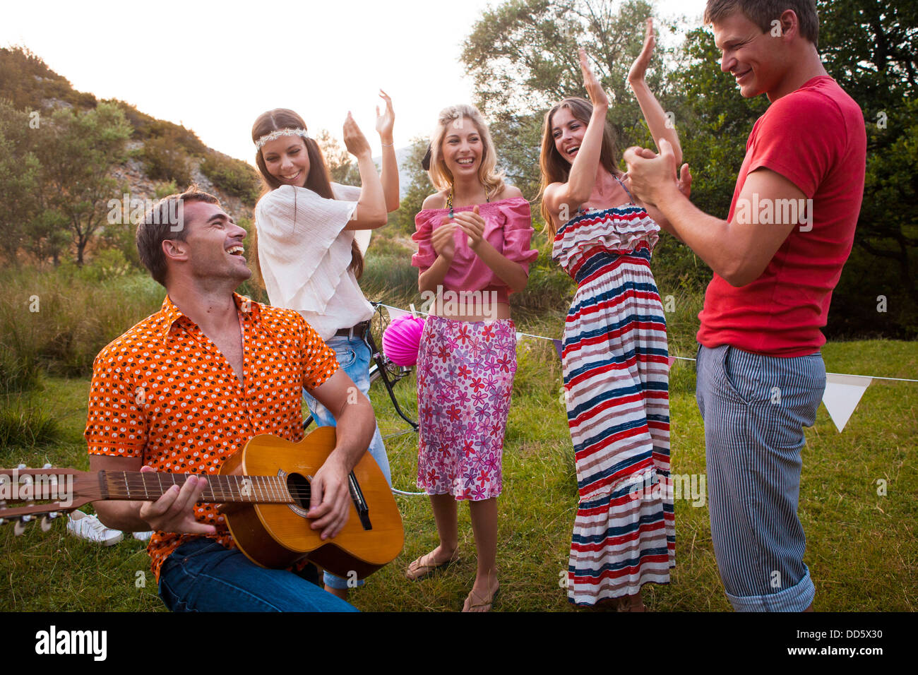 Croatia, Dalmatia, Young man playing guitar, women cheering Stock Photo