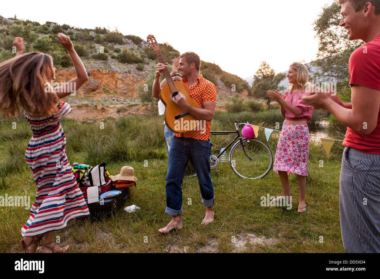 Croatia, Dalmatia, Young women dancing outdoors, man playing guitar Stock Photo