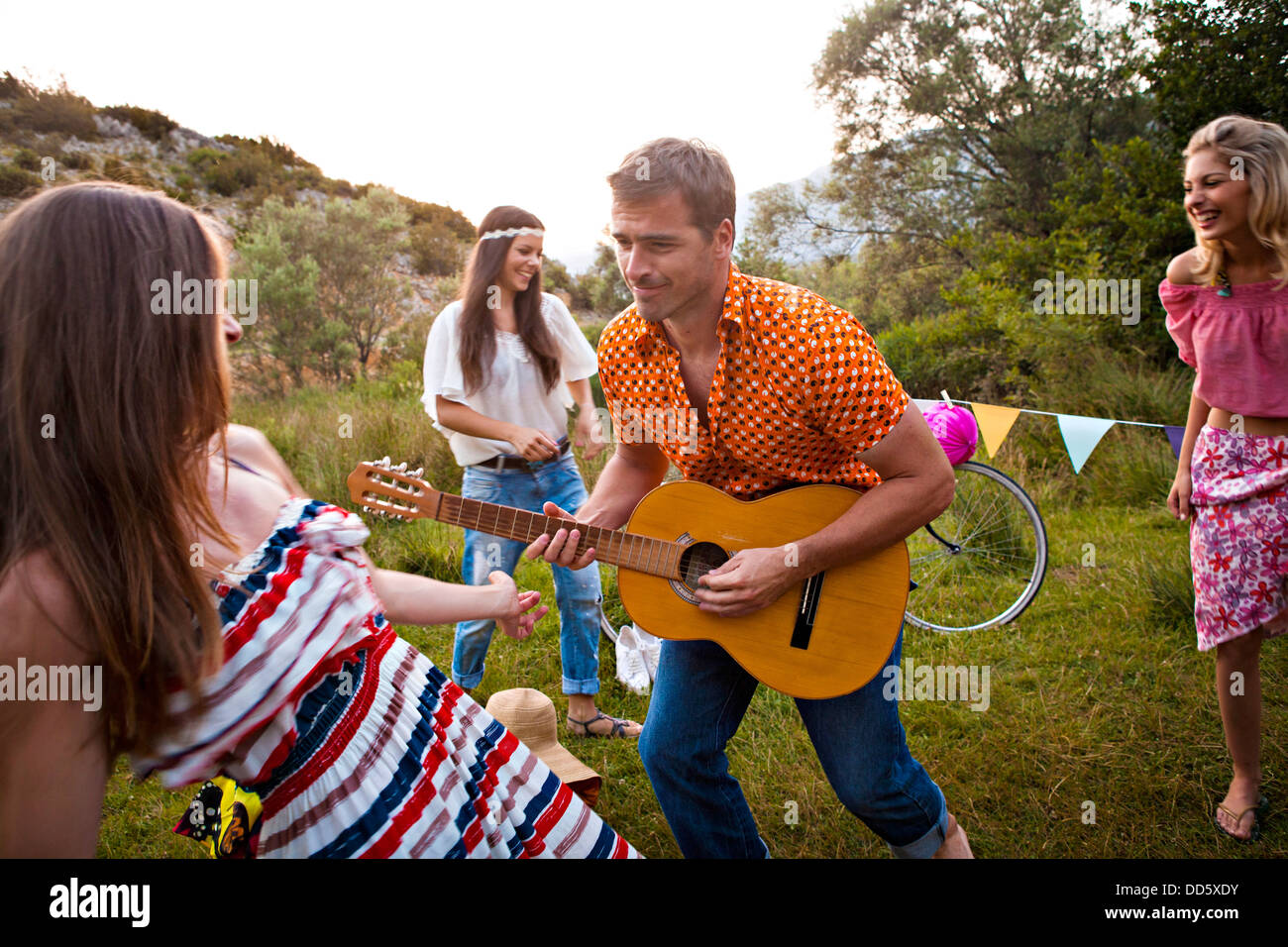 Croatia, Dalmatia, Young women dancing outdoors, man playing guitar Stock Photo