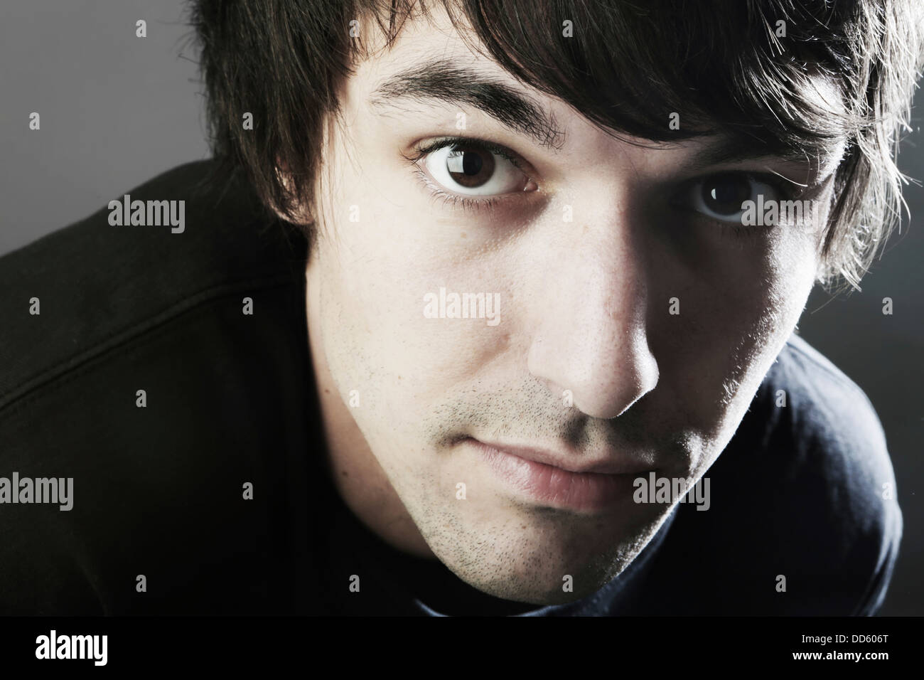 Portrait of young man against grey background, close up Stock Photo - Alamy