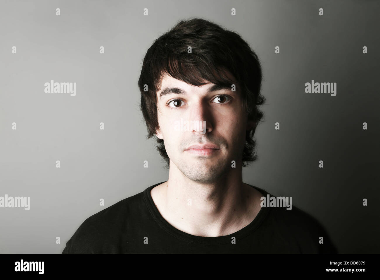 Portrait of young man against grey background, close up Stock Photo - Alamy