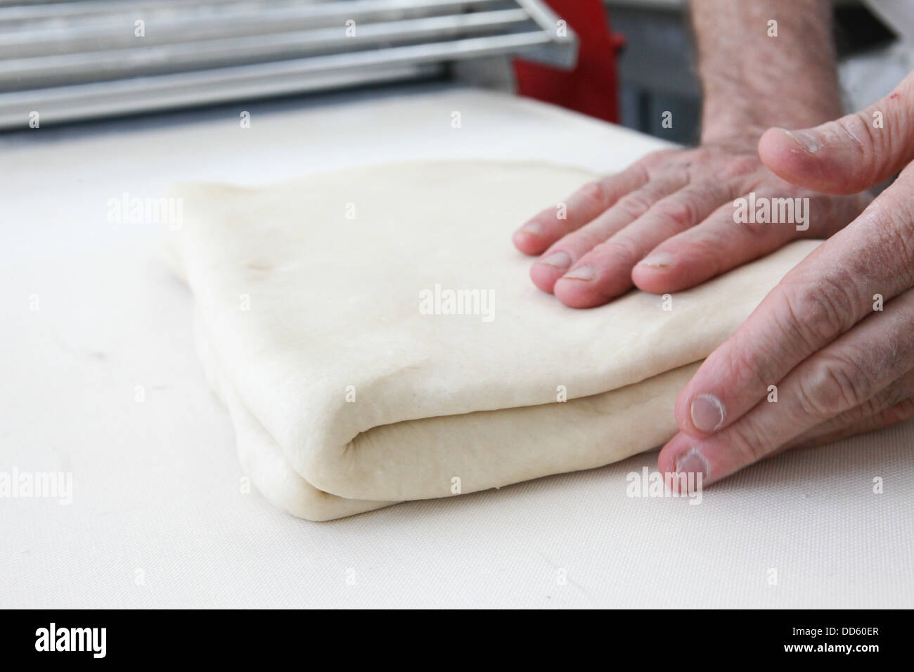 Making puff pastry at a bakery baker folds the dough Stock Photo