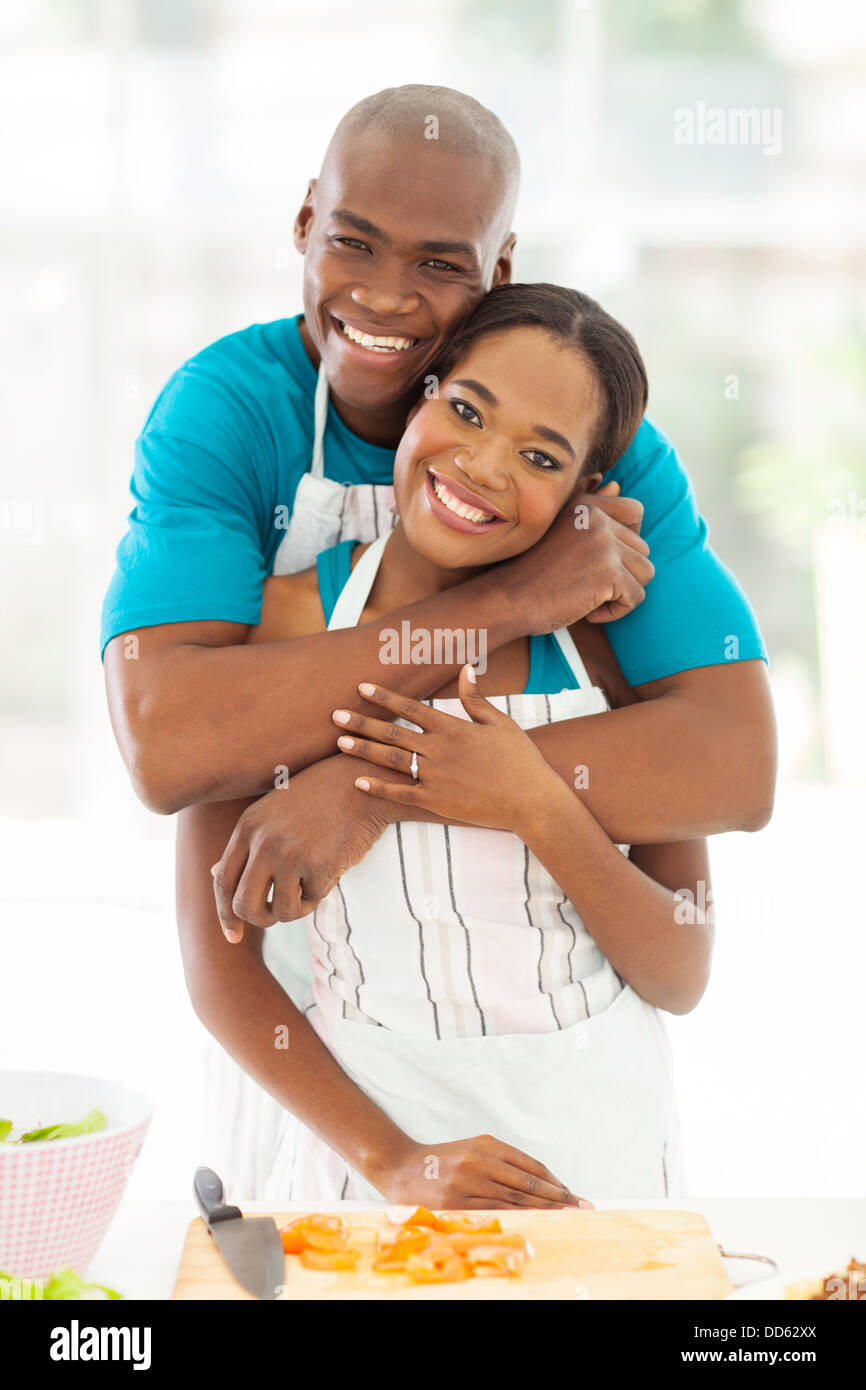 portrait of happy African couple hugging in kitchen at home Stock Photo ...