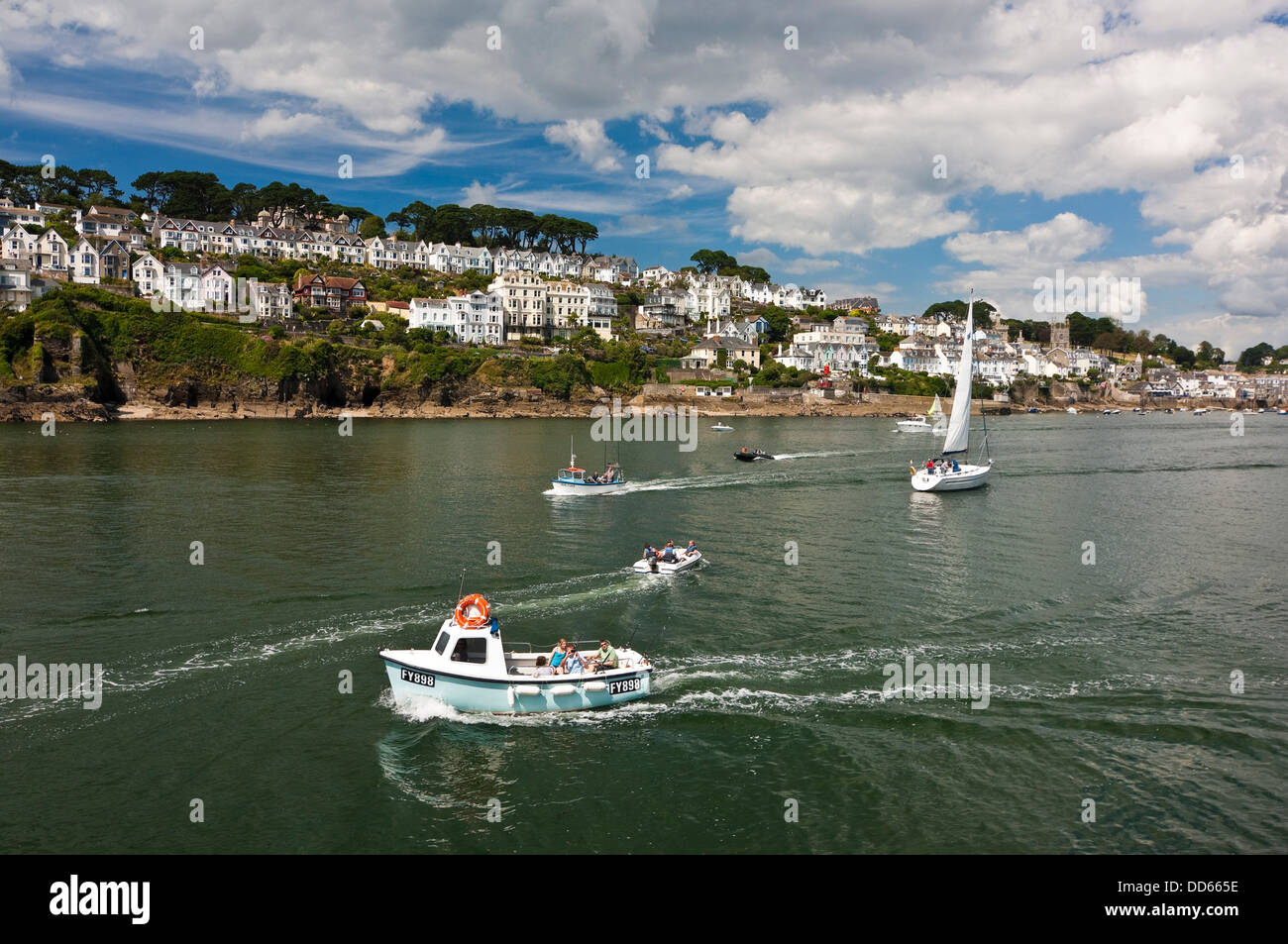 Horizontal view of Fowey with various types of boat sailing by on a sunny day. Stock Photo