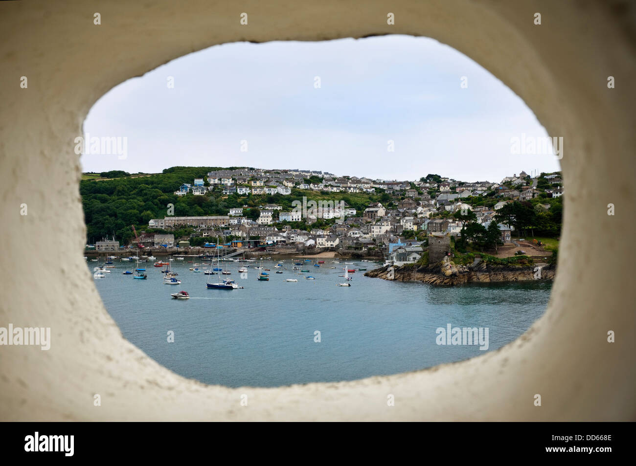 Horizontal view through a stone port hole towards Polruan and the old Blockhouse ruins. Stock Photo