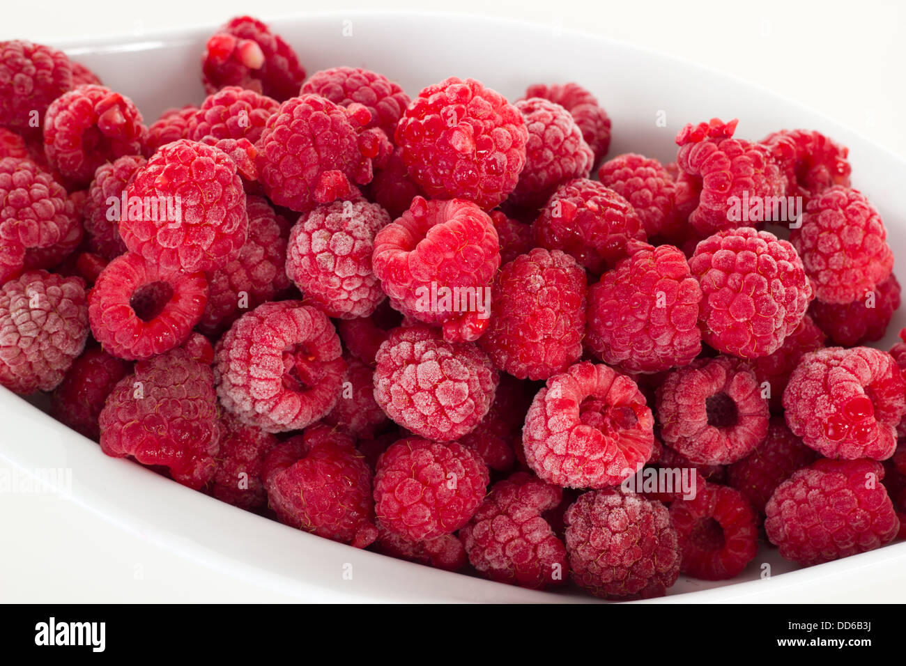 Frozen raspberries in white dish Stock Photo