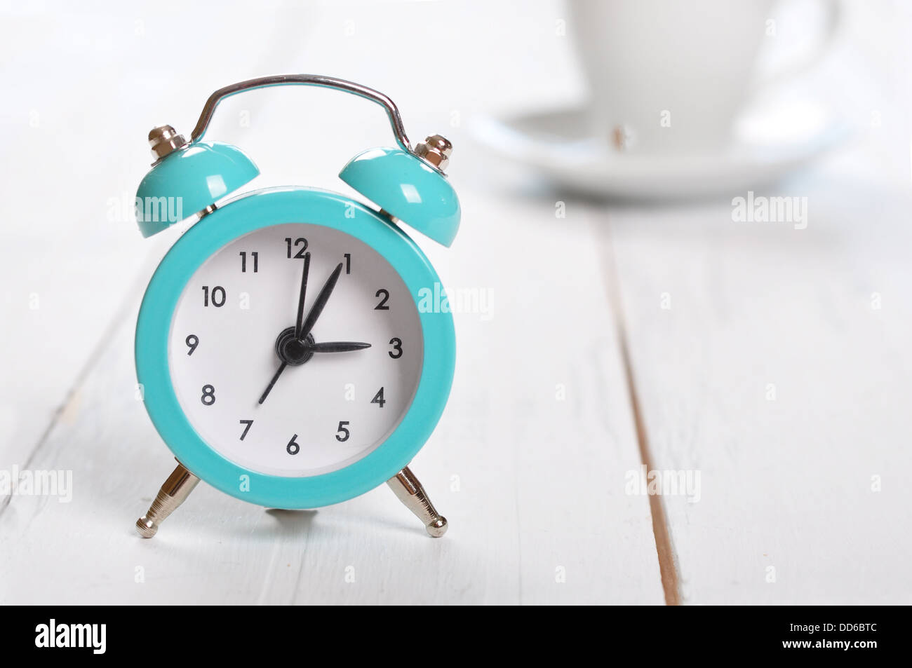 Vintage alarm clock with cup of coffee on white background Stock Photo