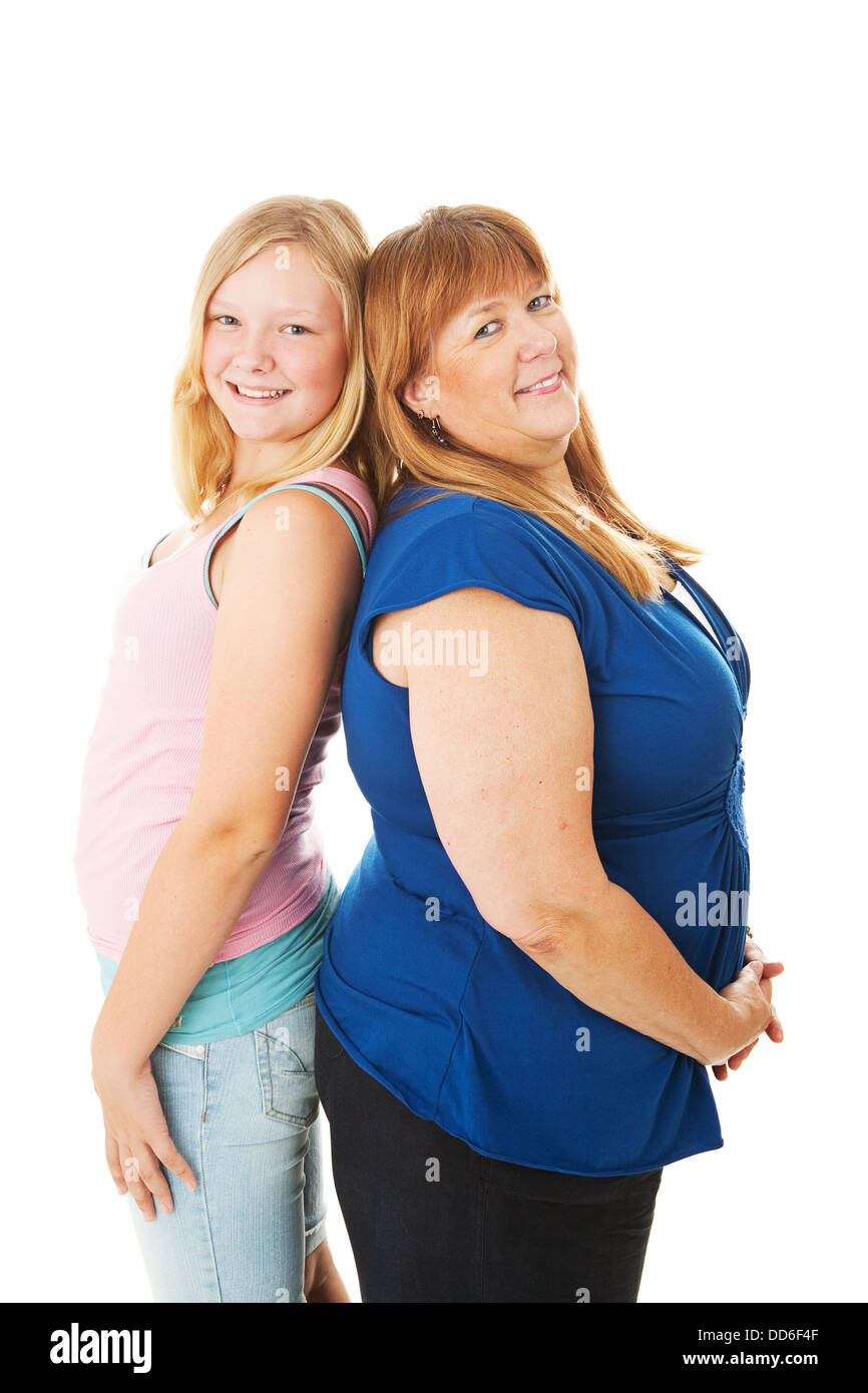 Pretty teenage daughter has grown taller than her mother. Isolated on white.  Stock Photo