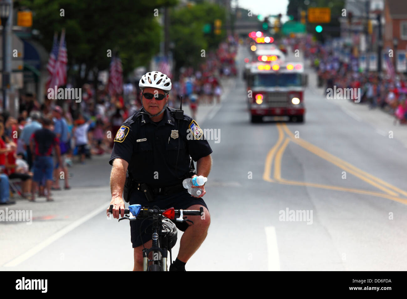 Policeman on bicycle on patrol during 4th of July Independence Day parades, Catonsville, Maryland, USA Stock Photo