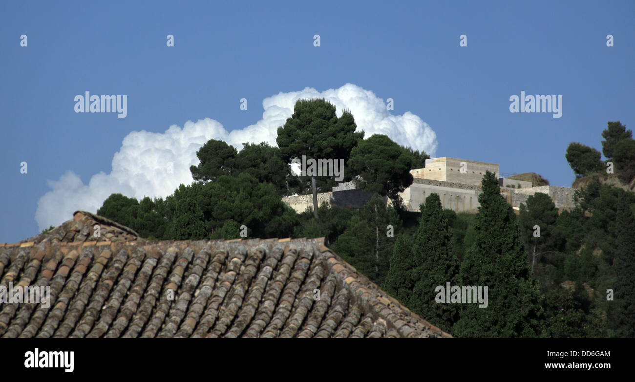 marshmallow clouds curl around trees at the alhambra, spain Stock Photo