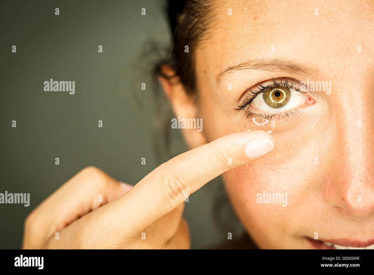 Studio, Frau setzt Kontaktlinse ins Auge ein Stock Photo