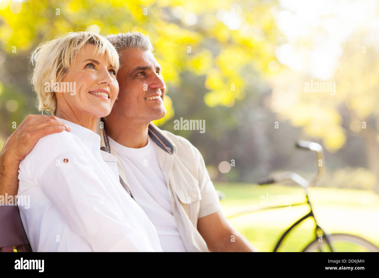 elegant mature couple sitting on a bench outdoors Stock Photo - Alamy