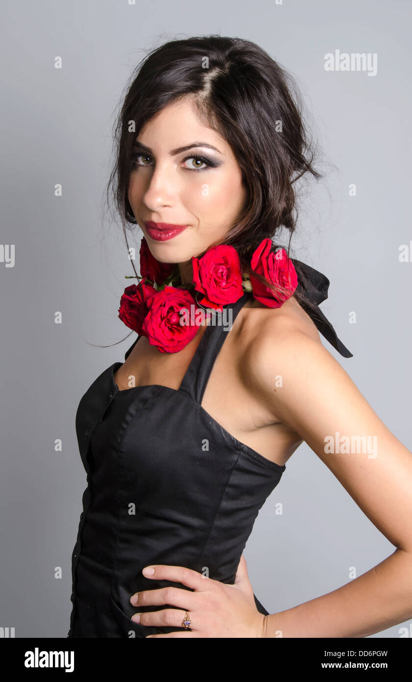 A beauty photograph of young woman/model adorned with red roses Stock Photo