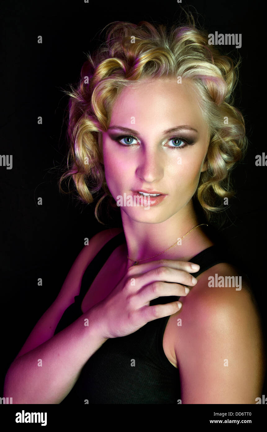 A beauty model poses fiercely in dramatic studio lighting, with Marilyn Monroe inspired hair Stock Photo