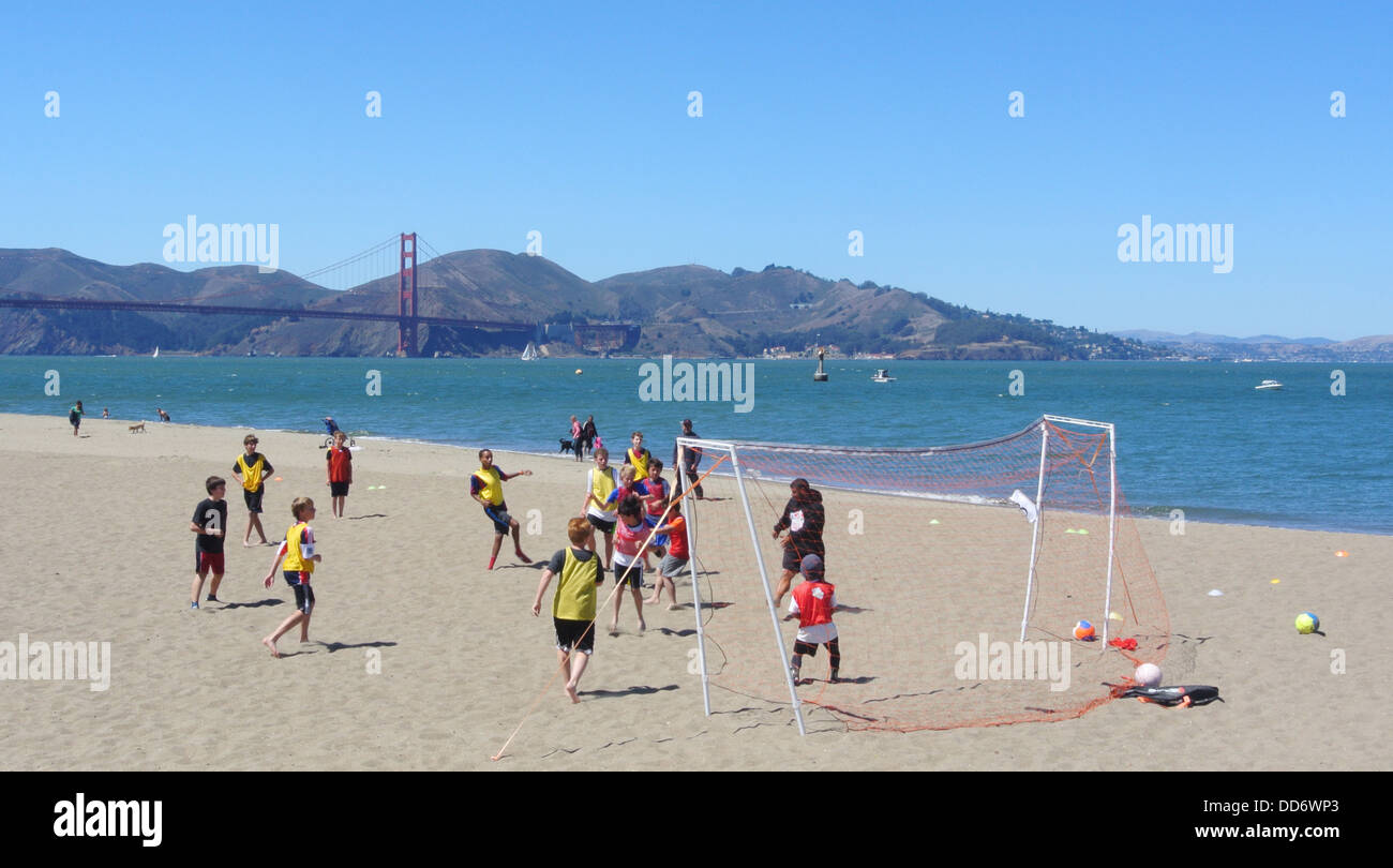 group of teenage boys playing soccer on the beach at Crissy Field San Francisco Stock Photo