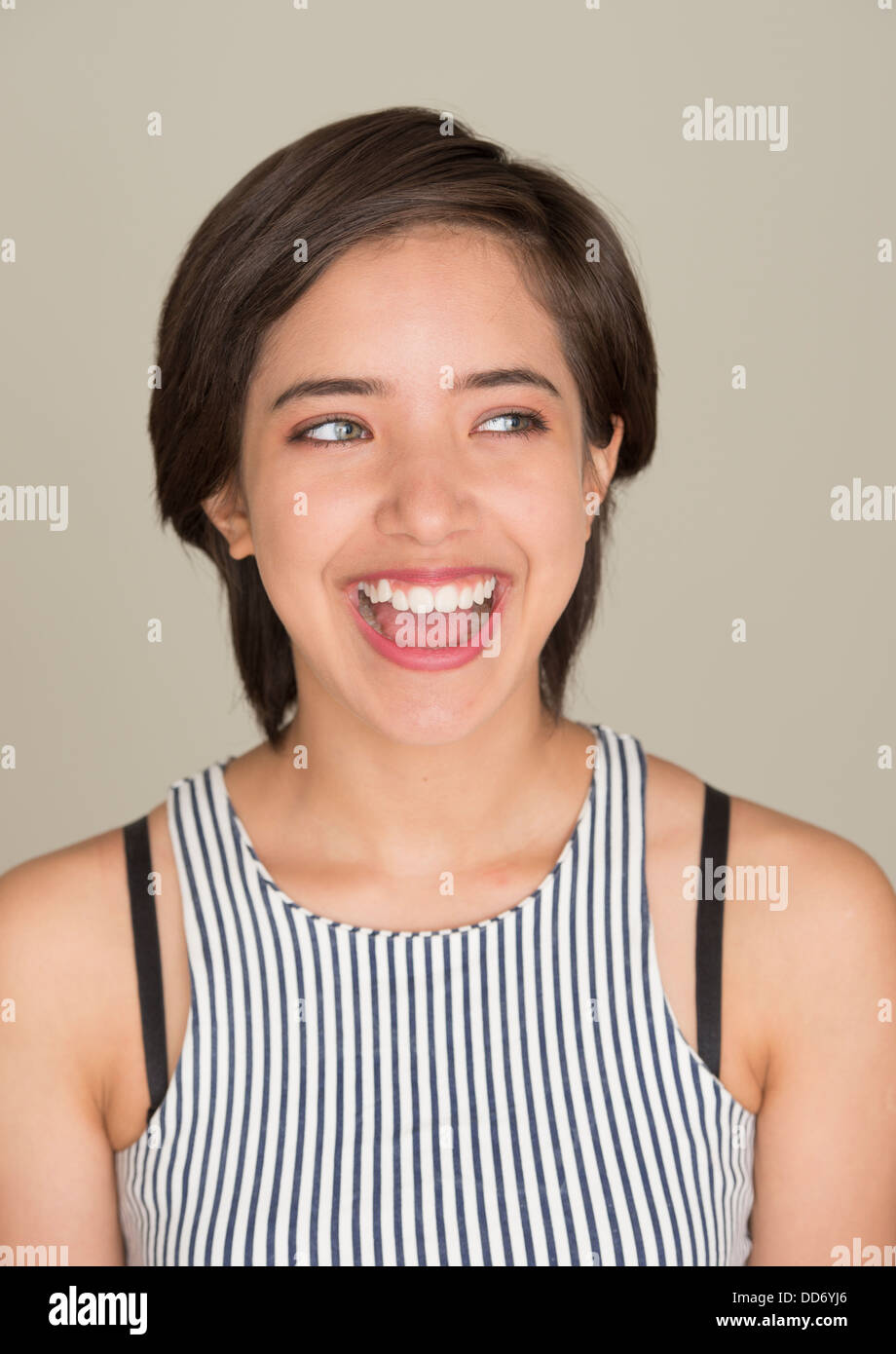 Happy and carefree young woman laughing and looking away Stock Photo